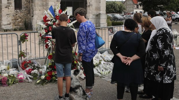 Residents pay tribute at a makeshift memorial in front of the Saint Etienne church where priest Jacques Hamel was killed.