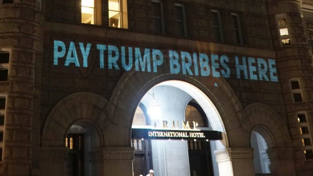 US President Donald Trump's Washington hotel is illuminated with projected messages by Robin Bell, an artist and filmmaker. 