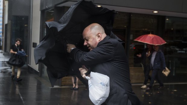 Commuters toil with Sydney's inclement weather.