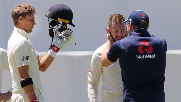 Big knock: Mark Stoneman is assessed after being hit on the head while batting.