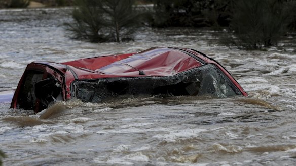 A four-wheel-drive vehicle in Paddys River upstream from the Cotter Reserve in the ACT. The driver died after trying to cross the raging torrent.
