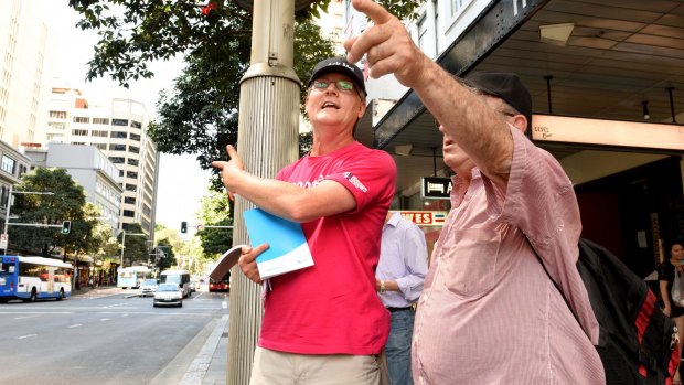 Sydney bus street team member Julian Buckell helps commuters in Park Street on Monday. 
