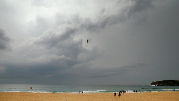 A seagull flies over Bondi beach as storm clouds start to dissipate.