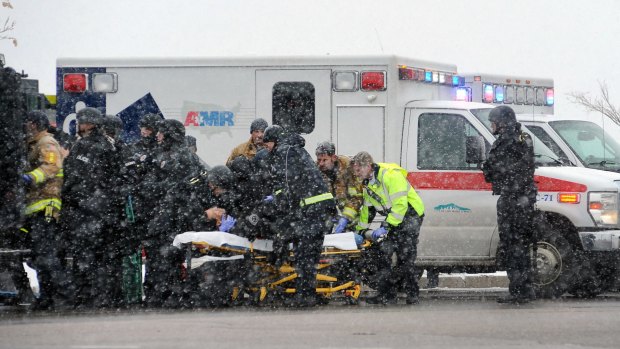 Emergency personnel transport an officer to an ambulance after reports of a shooting near the Planned Parenthood in Colorado Springs.