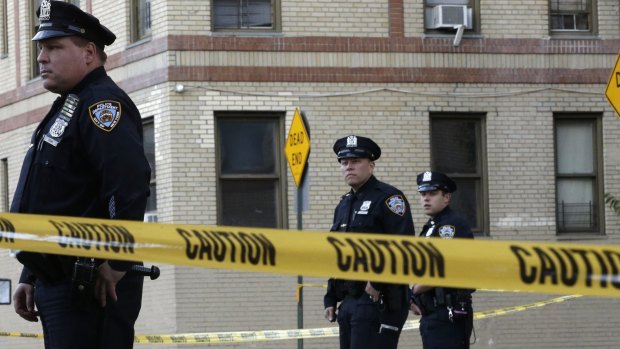 Police officers stand guard near the apartment building in the Bronx where the 6-month-old girl died.