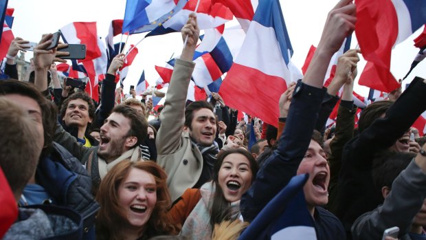 Supporters of Emmanuel Macron kiss as celebrate outside the Louvre museum in Paris.