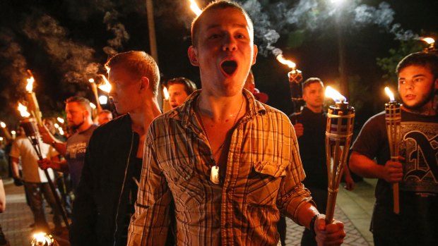 White nationalist groups march with torches through a university campus in Charlottesville.