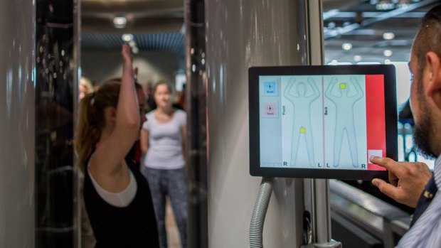 A passenger is screened using a full body scanner at the airport in Duesseldorf, Germany.