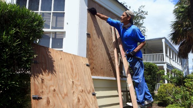 David Montes helps board windows at a home in preparation for Hurricane Harvey in Corpus Christi, Texas.