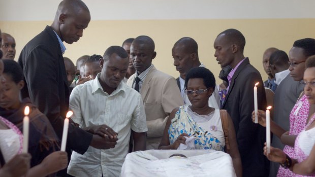 Friends and relatives gather around Egide Niyongere's coffin for a final goodbye.