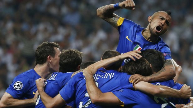 Juventus' Alvaro Morata (hidden) celebrates scoring their first goal with Arturo Vidal (top) and teammates.