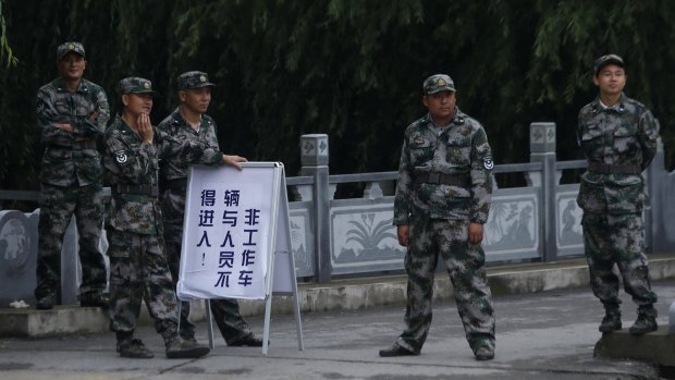 Chinese soldiers guard the entrance to the search and rescue site three days after a Chinese cruise ship capsized in Jianli.