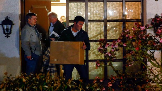 German police carry boxes out of a house believed to belong to the parents of Andreas Lubitz on Thursday.