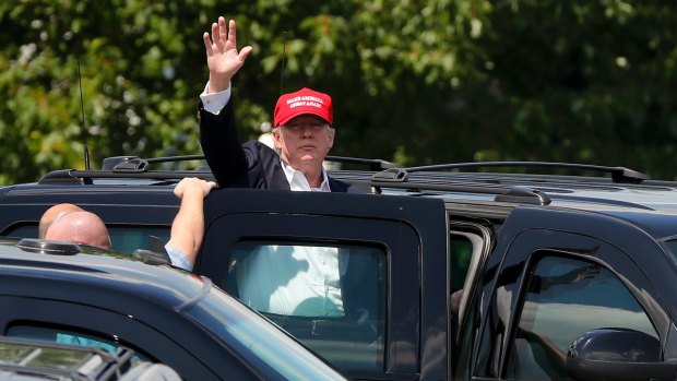 President Trump waves to spectators outside his residence at the Trump National Golf Club.