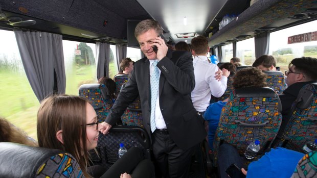 Bill English chatting to a young National's grandmother on phone in campaign bus.