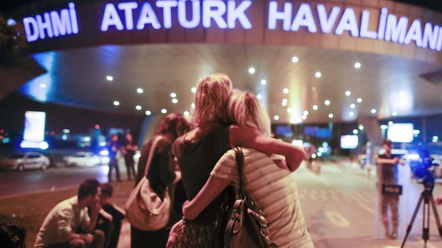 Passengers embrace each other at the entrance to Istanbul's Ataturk airport.