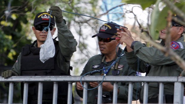 Members of the Thai explosive ordnance disposal unit recover pieces of evidence at the bridge over the Chao Phraya river.