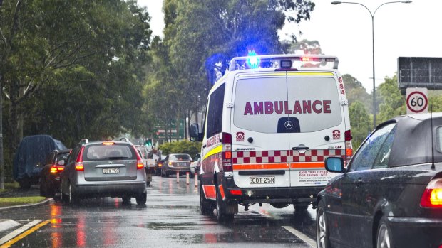 An ambulance battles chaotic traffic on South Dowling Street, Moore Park. 