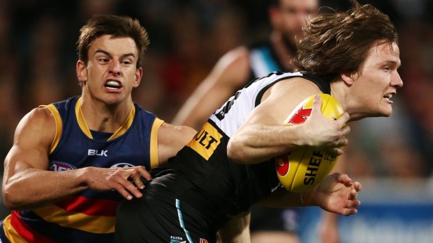 Port Adelaide's Jared Polec is  tackled by Jarryd Lyons of the Crows during Showdown 41.