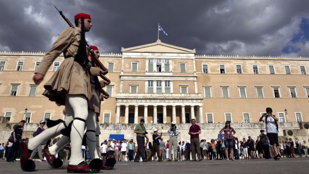 Evzoni presidental guards walk in front of the Greek parliament in Athens on Monday.