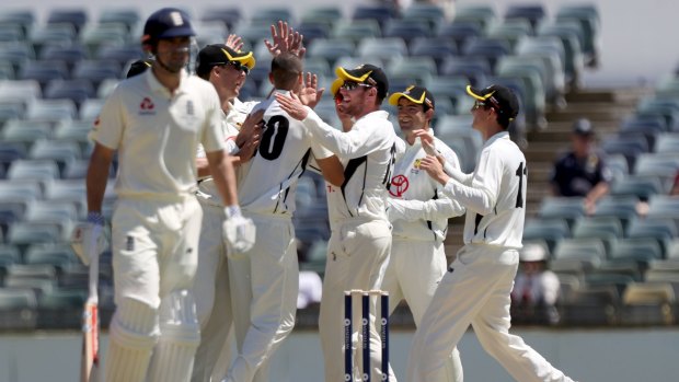 Nathan Coulter-Nile (centre) of Western Australia is congratulated by teammates after dismissing Alastair Cook of England during the England Men's tour of Australia cricket match between Western Australia and England at the WACA.