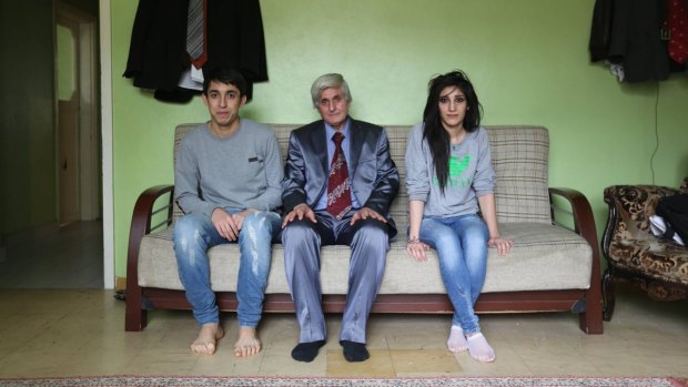 The man with his children, who were inside their house when it was hit by a missile, killing their mother and sister.