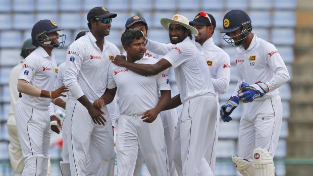 Dangerman: Spin bowler Rangana Herath and his Sri Lankan teammates celebrate the dismissal of David Warner in the first Test.