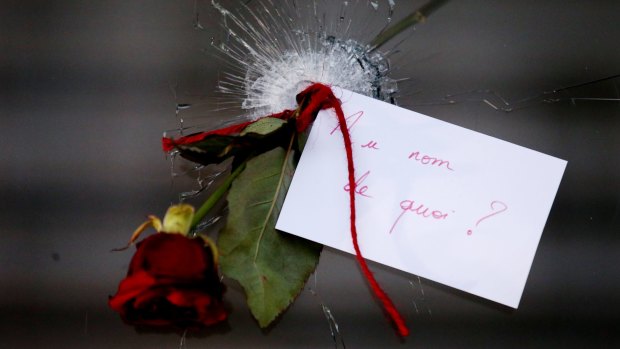 A rose in a bullet hole with a note that translates to "In the name of what?" at La Belle Equipe in Paris France on Sunday 15 November 2015. 