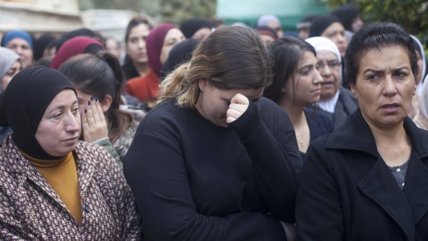 Relatives and friends stand next to the house of Arab Israeli woman Leanne Nasser during her funeral in Tira, Israel.