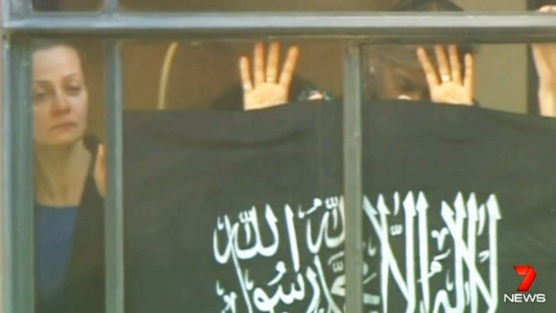 Hostage Marcia Mikhael against the window of the Lindt cafe during the siege.