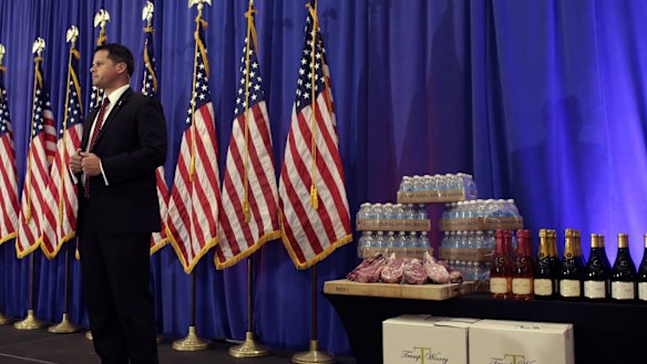 A secret service agent stands on the stage before a scheduled news conference by Donald Trump in Florida.