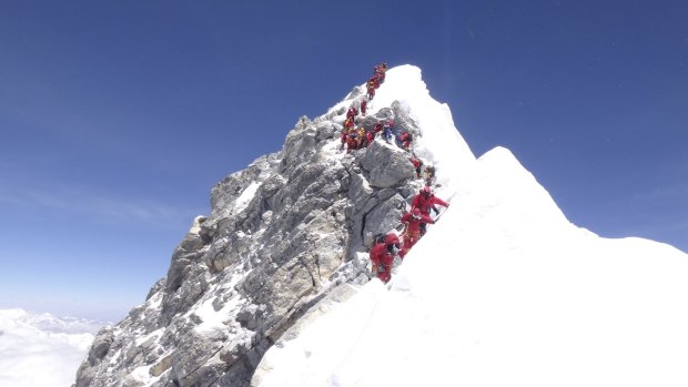 A conga line of climbers approaches the congested Hillary Step after reaching the summit of Mount Everest. 