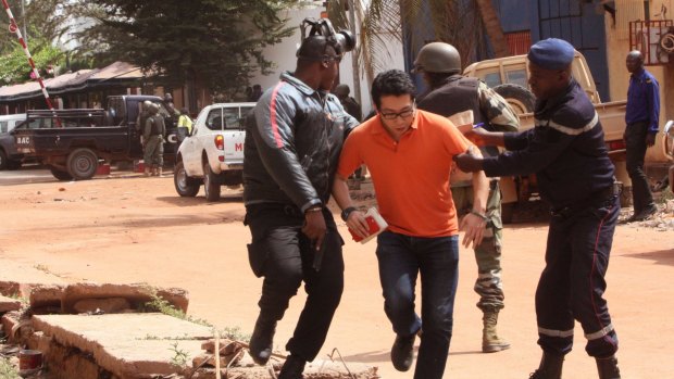 Mali security forces assist a hostage during Friday's attack.