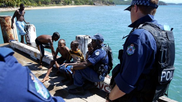 Police officers from the Personal Safety Response Team PSRT with Palm Island locals in the wake of the 2004 riots.