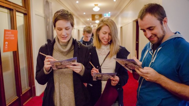 Verity Langer of Lyons, Clare Anderson of Kingston, and Brenden Watts of Kingston enjoy the puzzles on offer while lining up to vote at Old Parliament House.