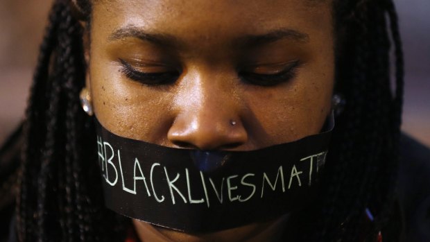 A protester wears tape over her mouth during a silent demonstration against what they say is police brutality after the Ferguson shooting of Michael Brown.