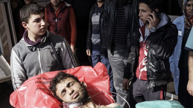 A wounded Syrian man is carried to a hospital in Kilis, Turkey. An air strike in the northern Syrian province of Idlib destroyed a makeshift clinic supported by an international aid group on Monday.