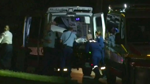 A 56-year-old man is loaded into an ambulance after being stabbed in Moorebank.