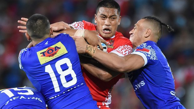 Feeling the squeeze: Albert Vete of Tonga takes on the Samoan defence.