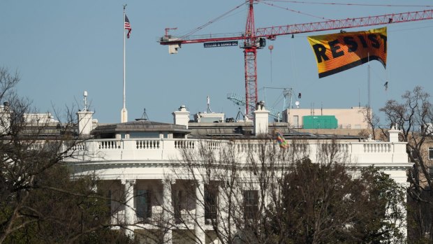 Greenpeace protesters unfurl a banner that reads "Resist" at a site near the White House.