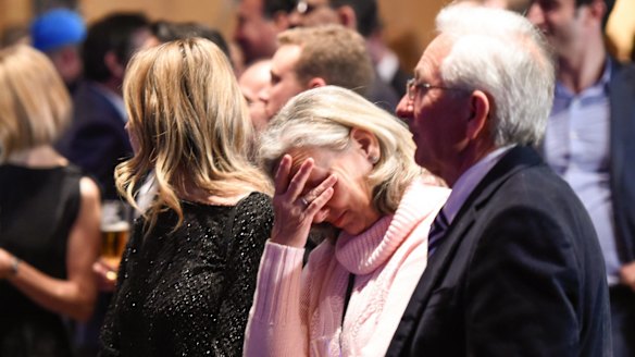 Malcolm Turnbull supporters listen to Bill Shorten give his speech on the screen at the Liberal Party election night function in Sydney.