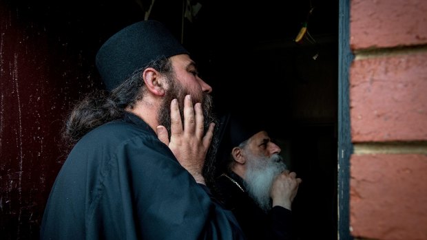 Father Nikodim Solunchev inspects damage to the electrical switchboard.