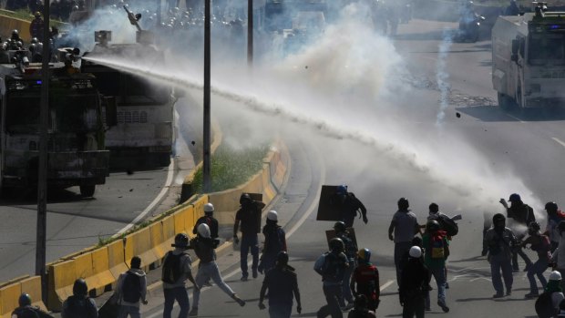 A water canon sprays government protesters trying to reach the Interior Ministry, in Caracas, Venezuela.