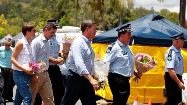 Acting Premier Tim Nicholls and senior police walk past the Cairns house where eight children died.