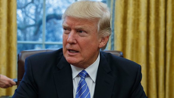 President Donald Trump sits at his desk in the Oval Office of the White House in Washington. 