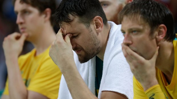 Shock defeat: Andrew Bogut reacts with teammates on the bench.