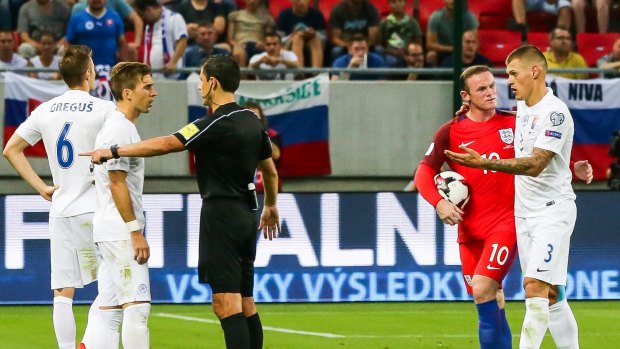 Slovakia's Martin Skrtel, right, speaks with England's Wayne Rooney, second right. Skrtel was sent off during the match.