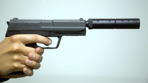 A gun with a silencer attached.