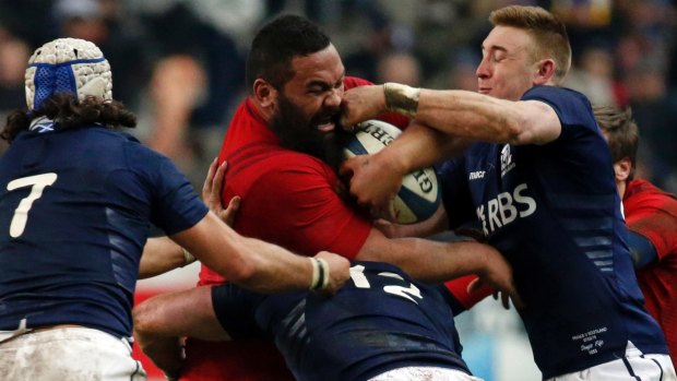 Huge unit: France's Uini Atonio is tackled by Scotland's Blair Cowan (L) and Dougie Fife (R).