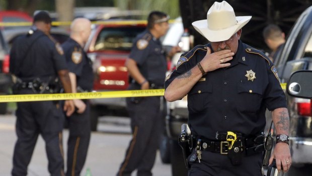 A Harris County Sheriff's Department officer walks away from the scene of the multiple shooting in Houston. 